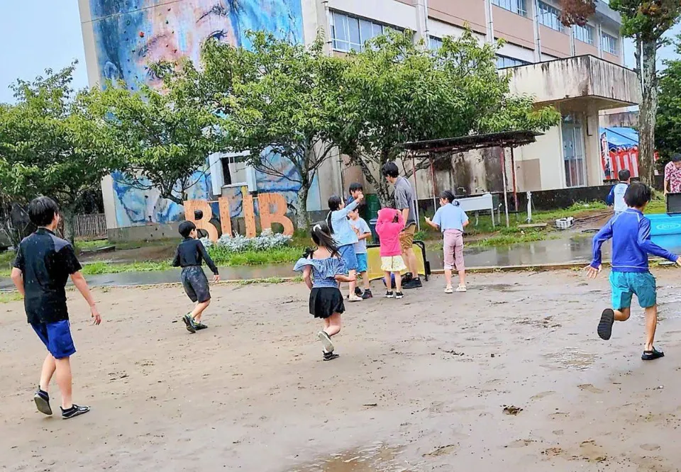 校舎前の広いフィールドでボール遊びをする子どもたち