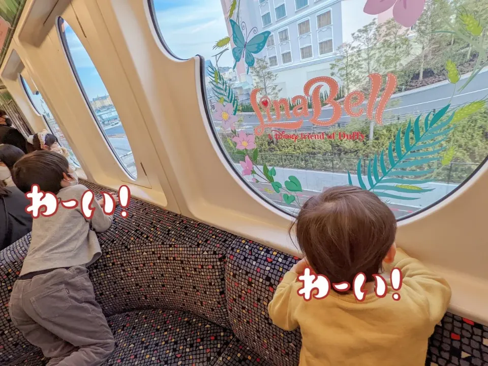 舞浜の屋内で、壁のポスターを見ながら並んで立つ子どもたち