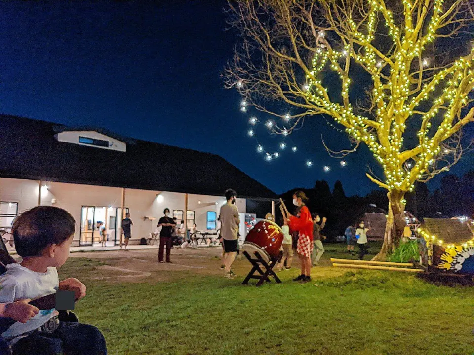 イルミネーションが灯る夜の庭で夏祭りを楽しむ親子