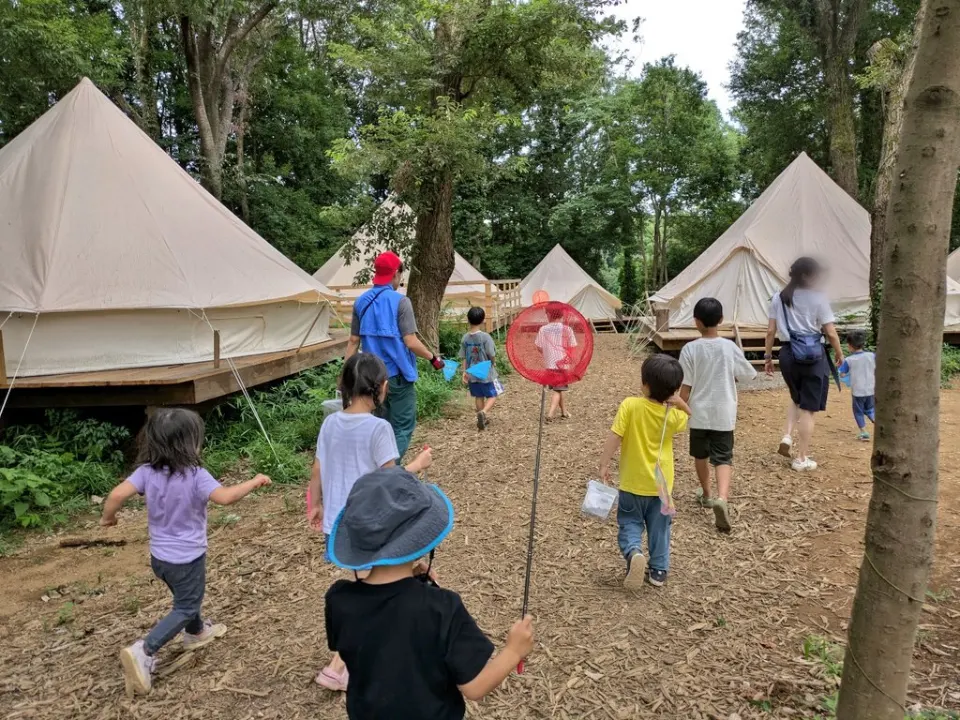 テントの前でクルーと遊ぶ子どもたち