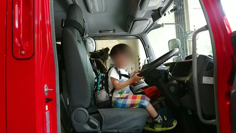 消防車の運転席に座る子ども