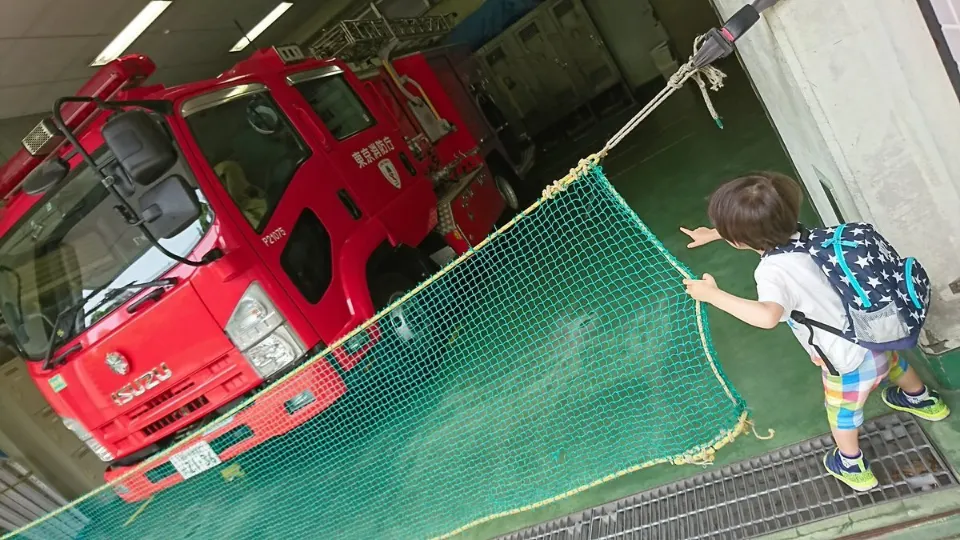 消防署で消防車を眺める子ども