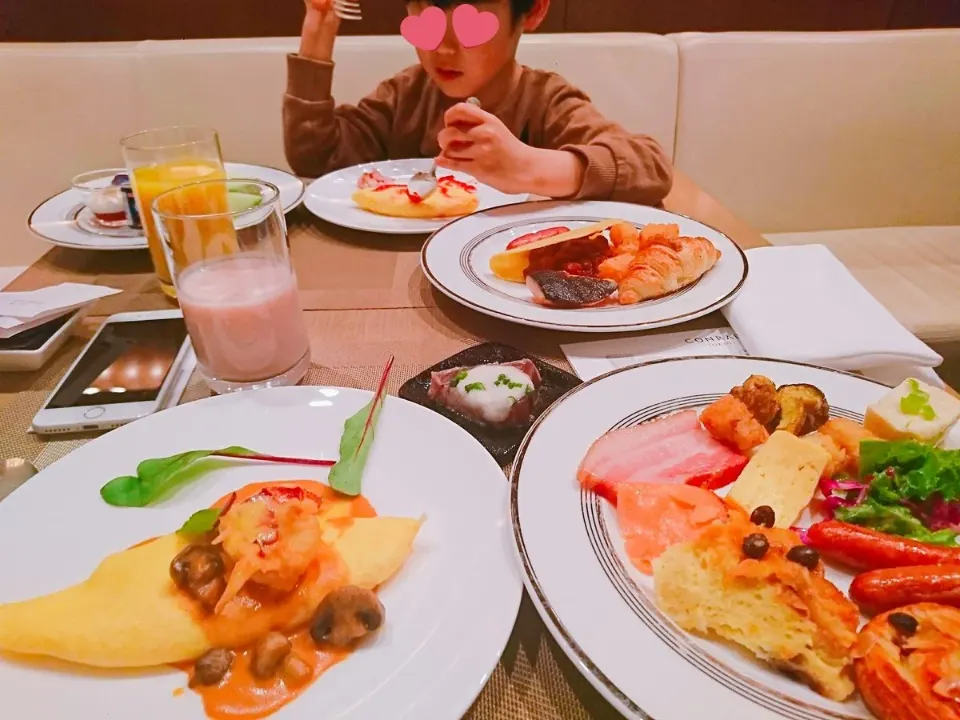 窓辺のテーブルで朝食を楽しむ親子