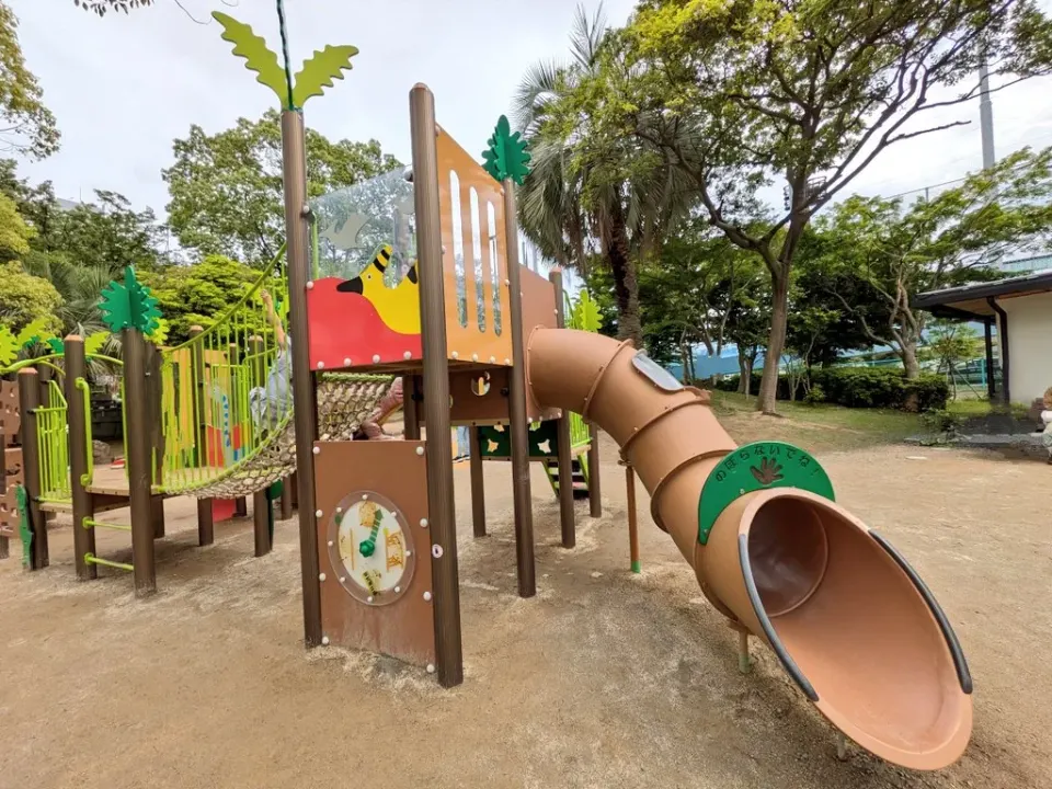 緑と茶色の幼児向け複合遊具と滑り台
