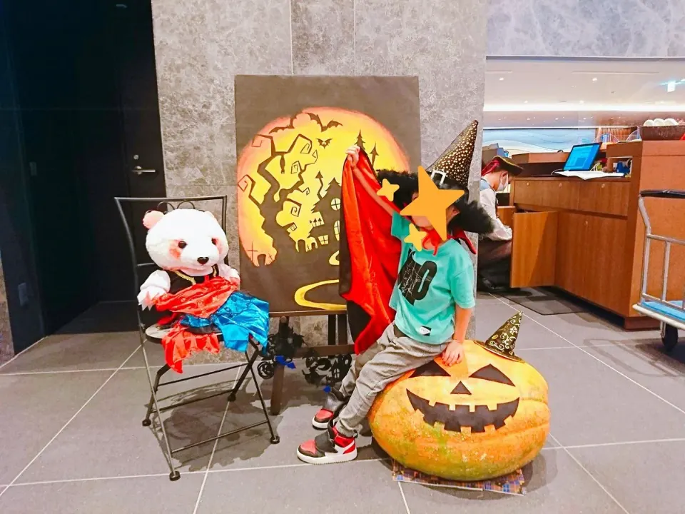ハロウィン飾りの前で仮装する子ども