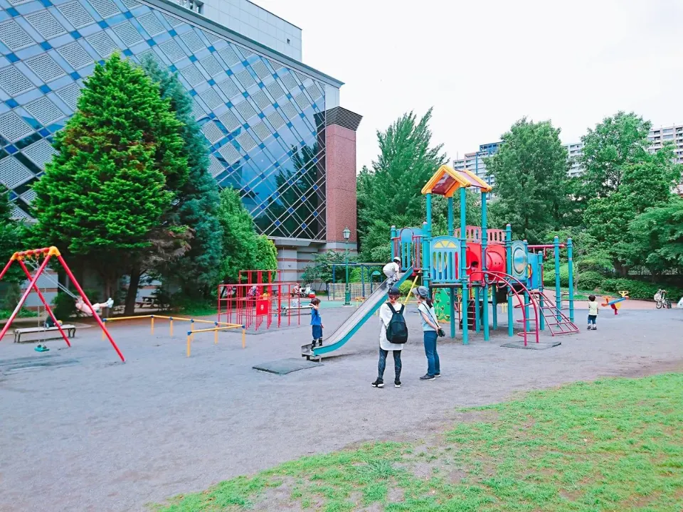 木々と建物に囲まれた遊具広場の全景