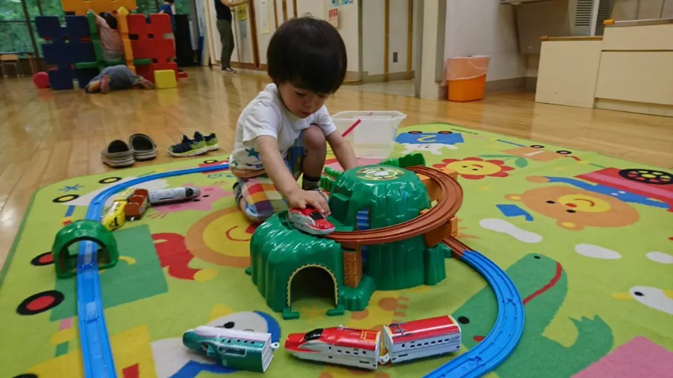 児童館のプラレールで遊ぶ子ども