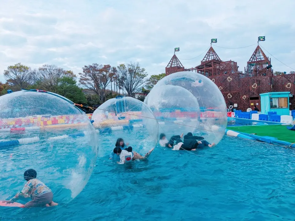 水上の透明なボールに入って遊ぶ子どもたち