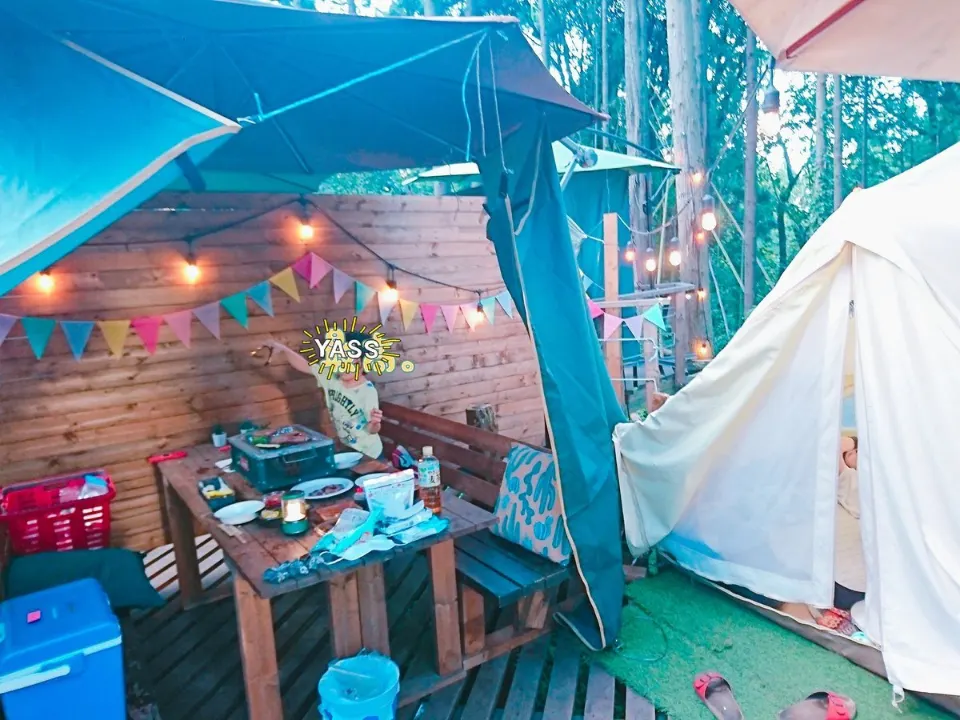 白いテント横の屋根付きデッキとテーブル