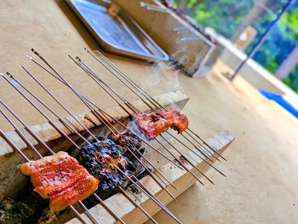 串を打った鰻を炭火で焼く蒲焼き体験