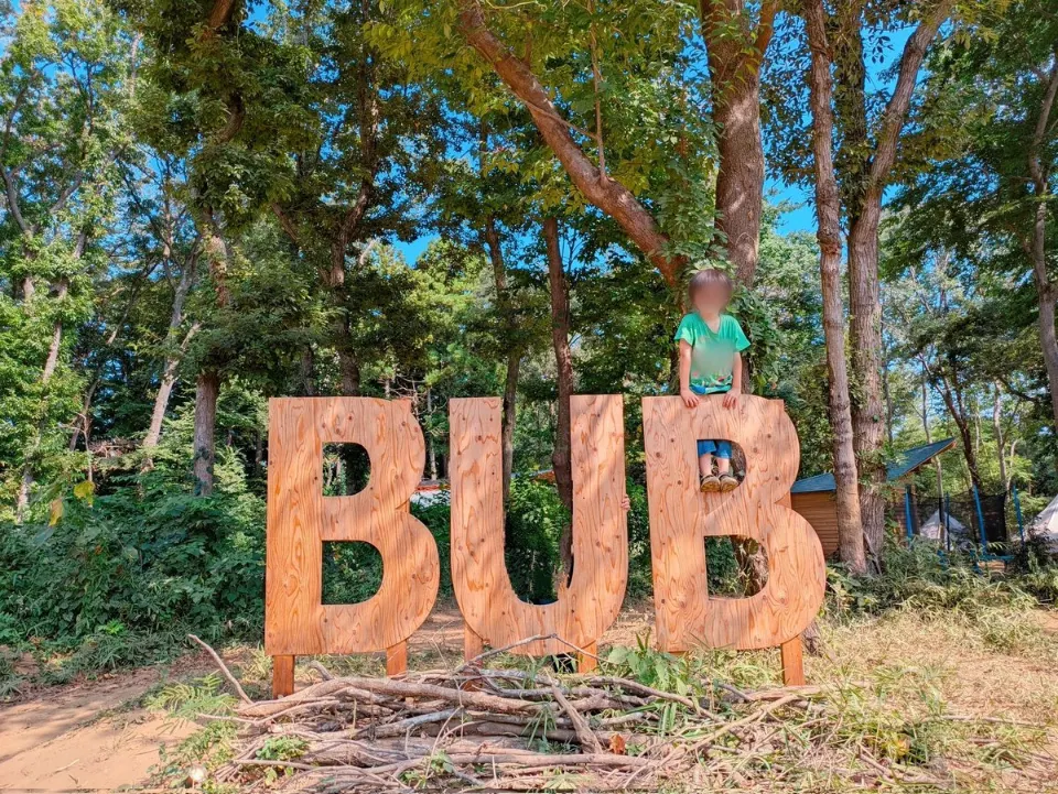 木々に囲まれたBUBの大きな文字の看板